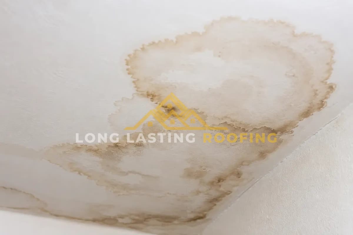 Brown water stain spreading across a ceiling from a roof leak